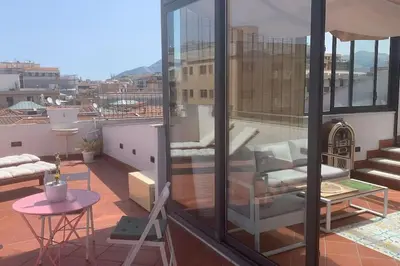 a balcony with a chair and a table on a building at ROCCA POLITEAMA Attico Prestigioso ed Eccitante. in Palermo
