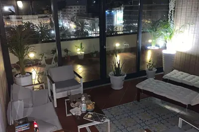 a living room with a view of a city at night at ROCCA POLITEAMA Attico Prestigioso ed Eccitante. in Palermo