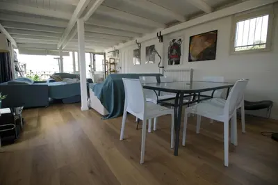 a dining room with a table and white chairs at Stunning Kalsa in Palermo
