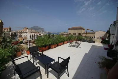 a patio with chairs and tables on a balcony at Stunning Kalsa in Palermo