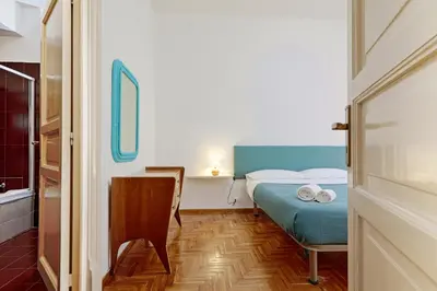 a small room with a bed and a chair at GuestHost - Teatro Massimo Lovely Flat with Balconies in Palermo
