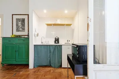 a kitchen with green cabinets and a microwave at GuestHost - Teatro Massimo Lovely Flat with Balconies in Palermo