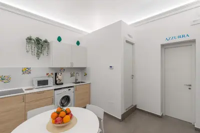 a kitchen with a table with a bowl of fruit on it at MolteVolte Rooms in Palermo