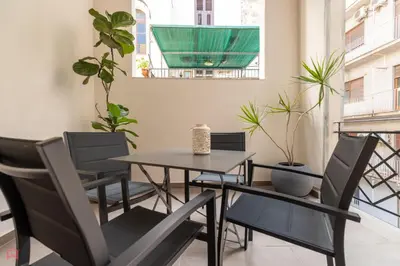 a table and chairs on a balcony with plants at MolteVolte Rooms in Palermo