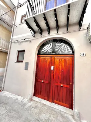 a pair of red doors on the side of a building at LB Home in Termini Imerese