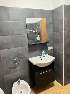 a bathroom with a sink and a toilet and a mirror at Casa Niní in Campofelice di Roccella