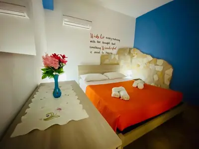 a bedroom with two beds and a vase of flowers on a table at Casa Niní in Campofelice di Roccella