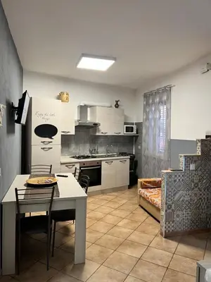 a kitchen with a table and a dining room at Casa Niní in Campofelice di Roccella