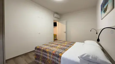 a hallway with two white doors and a wooden floor at Aura di Grecale in San Vito lo Capo