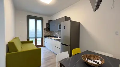 a kitchen with stainless steel appliances and a table at Aura di Grecale in San Vito lo Capo