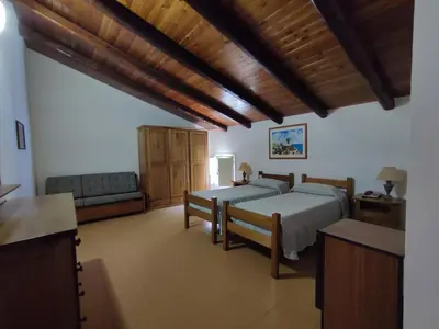 a bedroom with two beds and a couch in it at Allegroitalia Torre Artale Palermo in Trabia