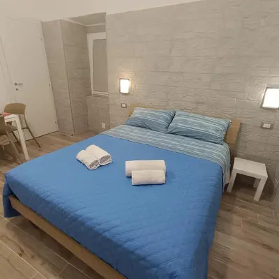 a blue bed with two towels on top of it at Casa alla Stazione in Palermo