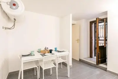 a white dining room with a white table and chairs at Casa Musicò in Palermo