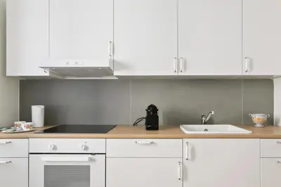a kitchen with white cabinets and a sink at GuestHost - NotHotel Palermo Central Bright Apartment in Palermo