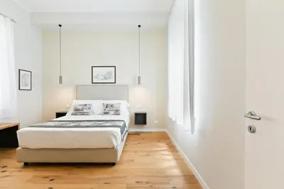 a white bedroom with a bed and a bathroom at GuestHost - NotHotel Palermo Central Bright Apartment in Palermo