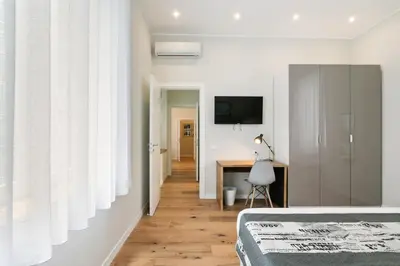 a bedroom with a bed and a desk and a television at GuestHost - NotHotel Palermo Central Bright Apartment in Palermo