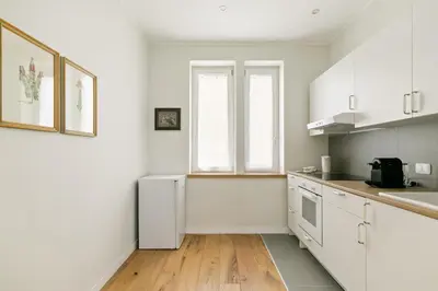 a kitchen with white cabinets and a white refrigerator at GuestHost - NotHotel Palermo Central Bright Apartment in Palermo