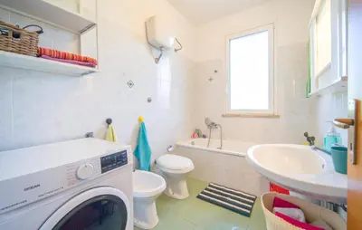 a bathroom with a washer and a toilet and a sink at Lovely Home In Piane Vecchie,Lascari in Lascari