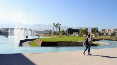 a person walking in front of a fountain at Cala Apartment Centre in Palermo