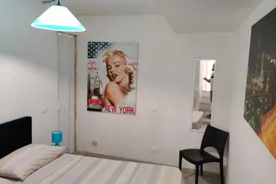 a bedroom with a bed and a poster of a woman at Cala Apartment Centre in Palermo