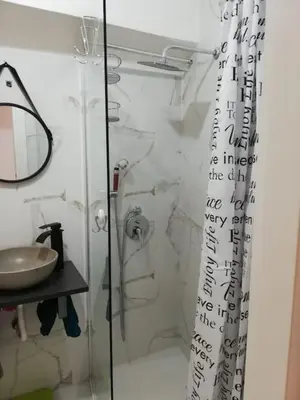 a bathroom with a glass shower with a sink at Cala Apartment Centre in Palermo