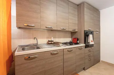 a kitchen with wooden cabinets and a sink at Casa in Villa a Mondello-700m dal mare in Palermo