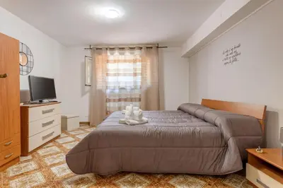 a bedroom with a bed with a teddy bear on it at Casa in Villa a Mondello-700m dal mare in Palermo