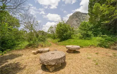 a group of stone benches sitting on a field at Amazing Home In San Giuseppe Jato in San Giuseppe Jato