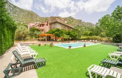 a large pool with lawn chairs and a building at Amazing Home In San Giuseppe Jato in San Giuseppe Jato