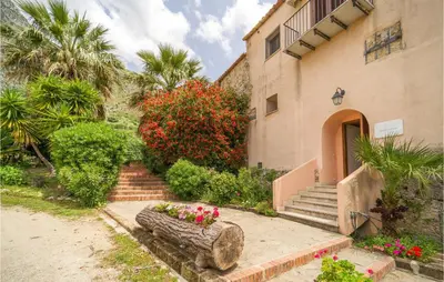 a house with a staircase and flowers in a yard at Rosmarino in San Giuseppe Jato