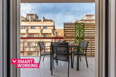a table and chairs on a balcony with a view of a city at Appartamento Libertà con Terrazza by Wonderful Italy in Palermo