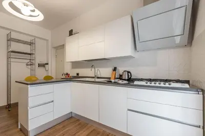a white kitchen with white cabinets and a sink at Appartamento Libertà con Terrazza by Wonderful Italy in Palermo