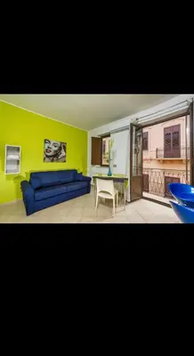 a living room with a blue couch and a table at Principe Tancredi in Castellammare del Golfo