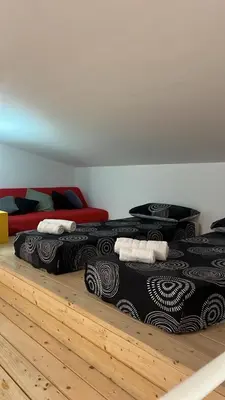 a group of three beds sitting on a wooden floor at Villa Laura in Cefalù