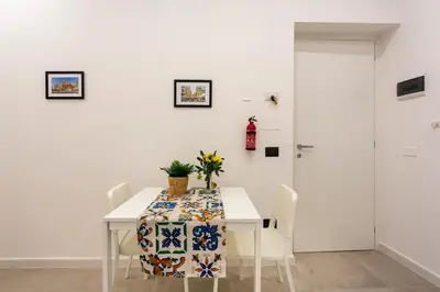 a white dining room with a table and chairs at Palermo Central in Palermo