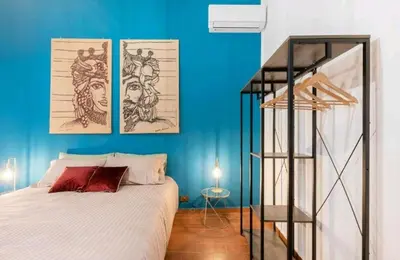 a bedroom with a bed and a blue wall at DaMé in Palermo