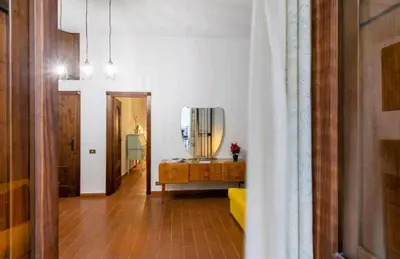 a living room with a mirror and a yellow couch at DaMé in Palermo