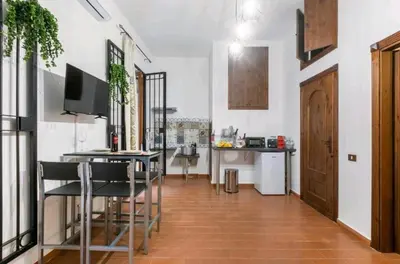 a living room with a table and chairs and a kitchen at DaMé in Palermo