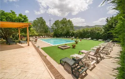 a swimming pool with chairs and a lawn with a pool at Salvia in San Giuseppe Jato
