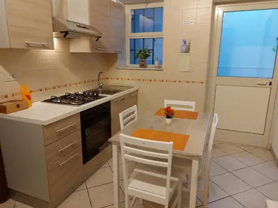 a kitchen with a table and a sink and a stove at CASA di ARTHUR in Palermo