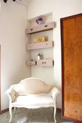 a white bench sitting in a room with shelves at Sicilia Nica - appartamento privato a Cinisi (PA) in Cinisi
