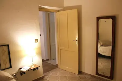 a room with a mirror and a bed and a lamp at Sicilia Nica - appartamento privato a Cinisi (PA) in Cinisi