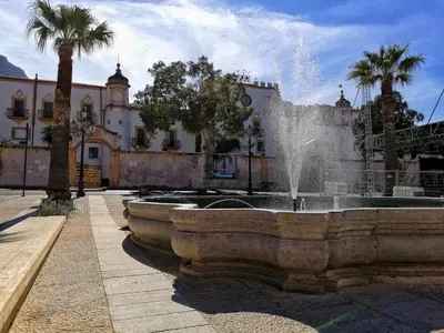 a fountain in front of a building with palm trees at Sicilia Nica - appartamento privato a Cinisi (PA) in Cinisi