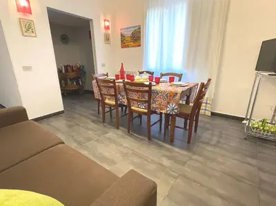 a dining table and chairs in a living room at Residenza Lincoln in Palermo