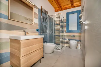a bathroom with a sink and two toilets at Villa Holidays in Torre Bennistra in Scopello