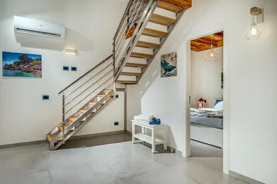 a staircase in a room with a bed and a bedroom at Villa Holidays in Torre Bennistra in Scopello