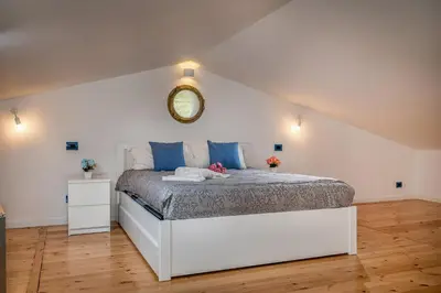 a bedroom with a bed with a clock on the wall at Villa Holidays in Torre Bennistra in Scopello
