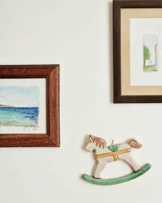 a toy horse on a wall next to two pictures at Casa Al Plumbago in Termini Imerese