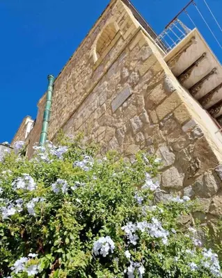 a brick building with flowers in front of it at Casa Al Plumbago in Termini Imerese