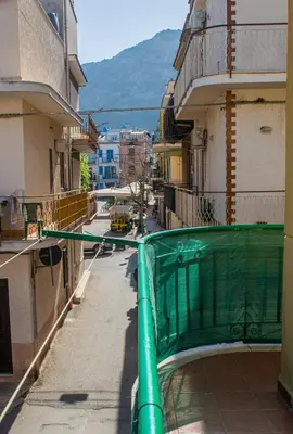 a balcony with a green fence on a city street at Ciuri Ciuri in Isola delle Femmine